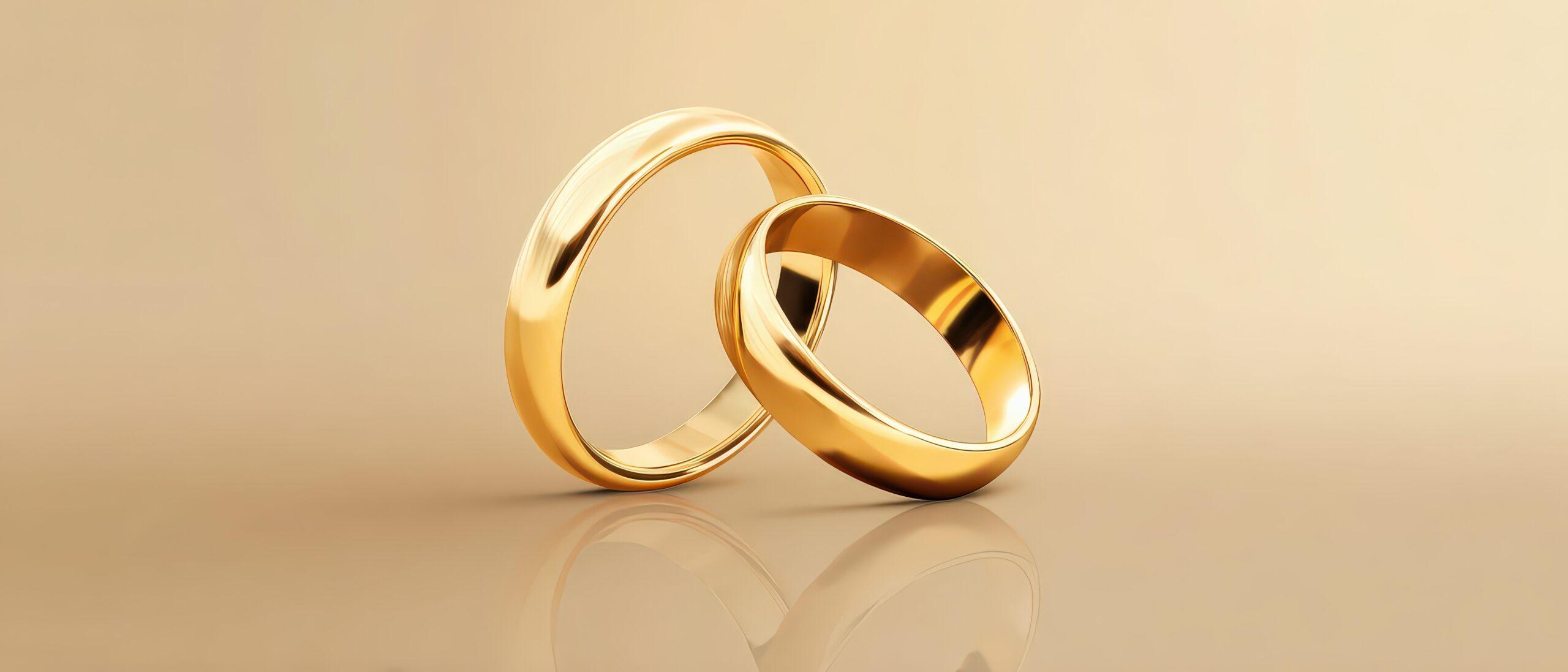Zwei schlichte Eheringe aus Gold auf spiegelnder Flaeche – Symbol fuer dauerhafte emotionale Verbindung