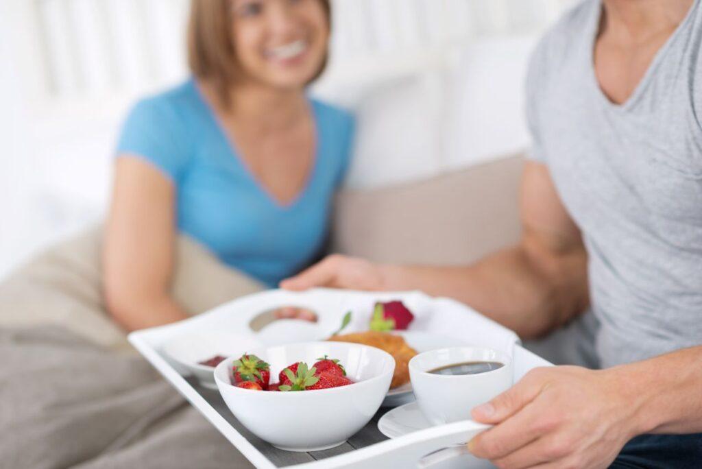 Ein Partner bringt dem anderen ein Fruehstueck ans Bett – Ritual fuer Naehe und Beziehungspflege, inspiriert vom Gedanken hinter dem Ehering Gold